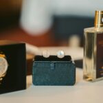 Sophisticated men's watch and cufflinks displayed on a table alongside a bottle of perfume.